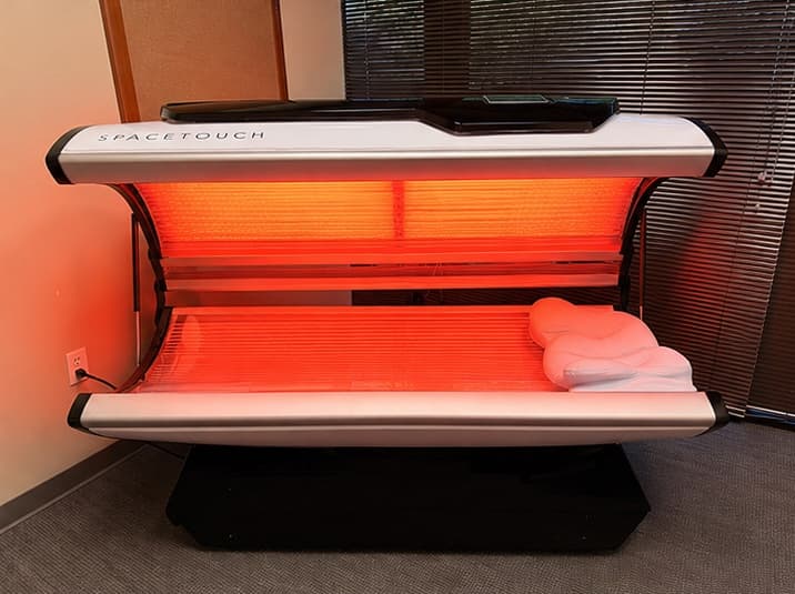 The capsule fully open, its interior filled with warm red therapeutic light